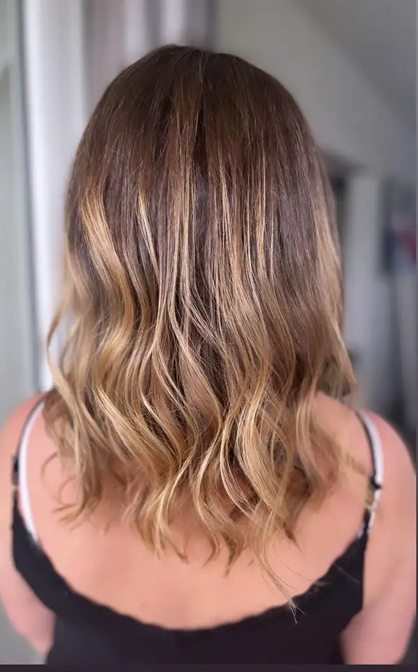 Coloration blond miel ondulée sur cheveux mi-longs, réalisée par Julie DreamColor
