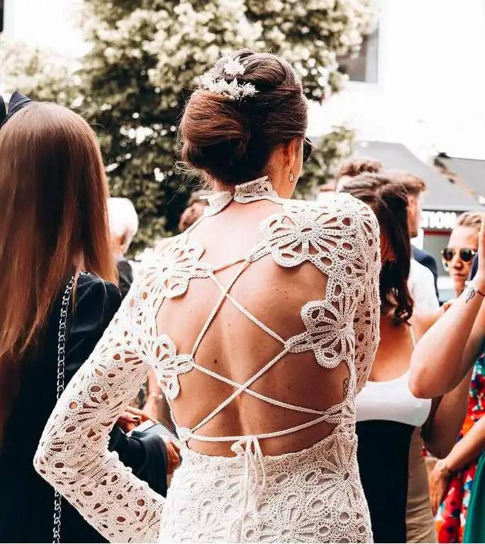 Mariée en robe dos nu en dentelle avec un chignon chic et un peigne bijou, coiffure Julie DreamColor