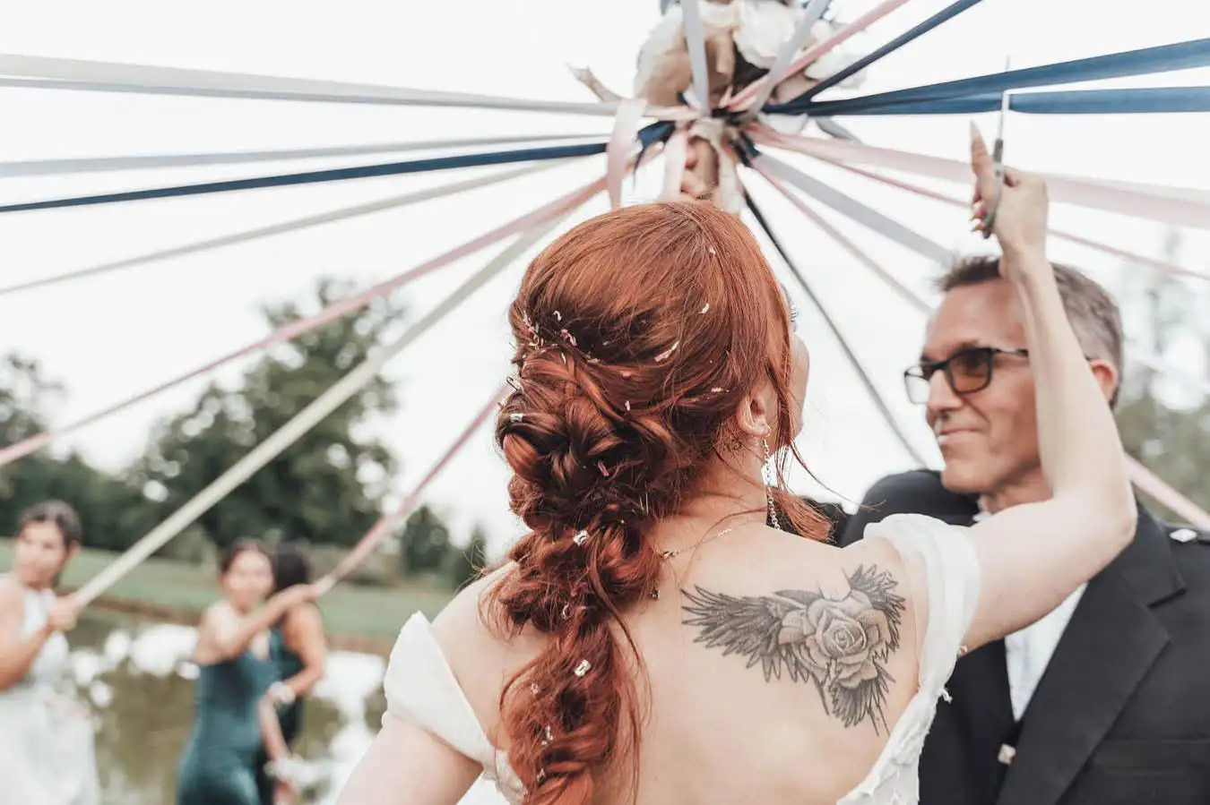 Mariée rousse avec une tresse en queue basse, coiffure Julie DreamColor, lors de la cérémonie