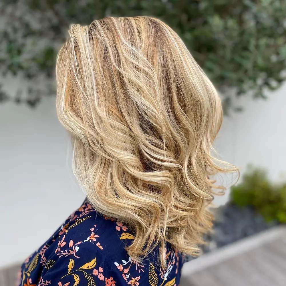 Balayage blond lumineux sur cheveux mi-longs ondulés, réalisé par Julie DreamColor près de Bordeaux