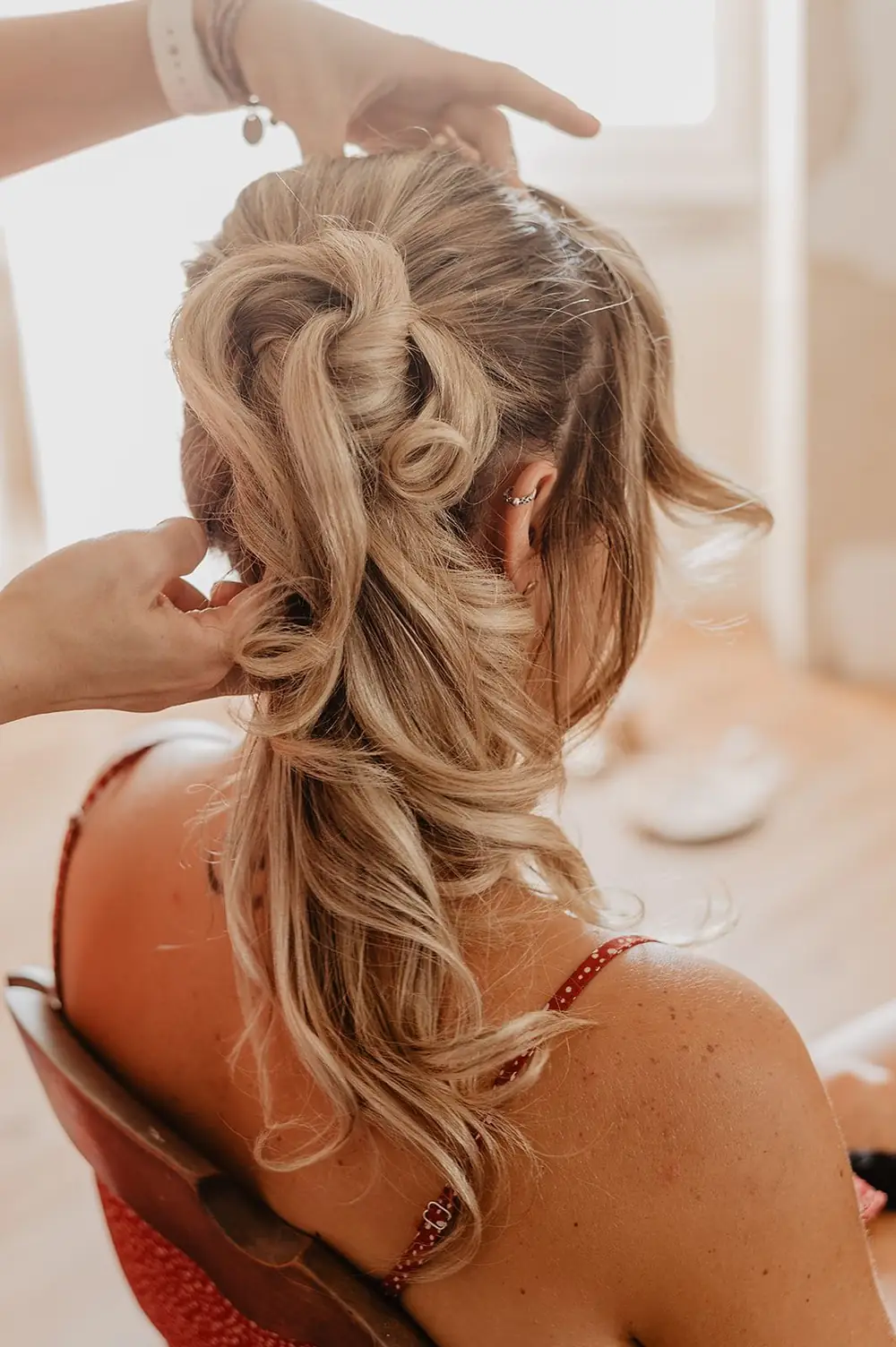 Julie DreamColor réalise une attache haute aux boucles wavy sur cheveux blonds lors d'un essai coiffure de mariage à Mérignac